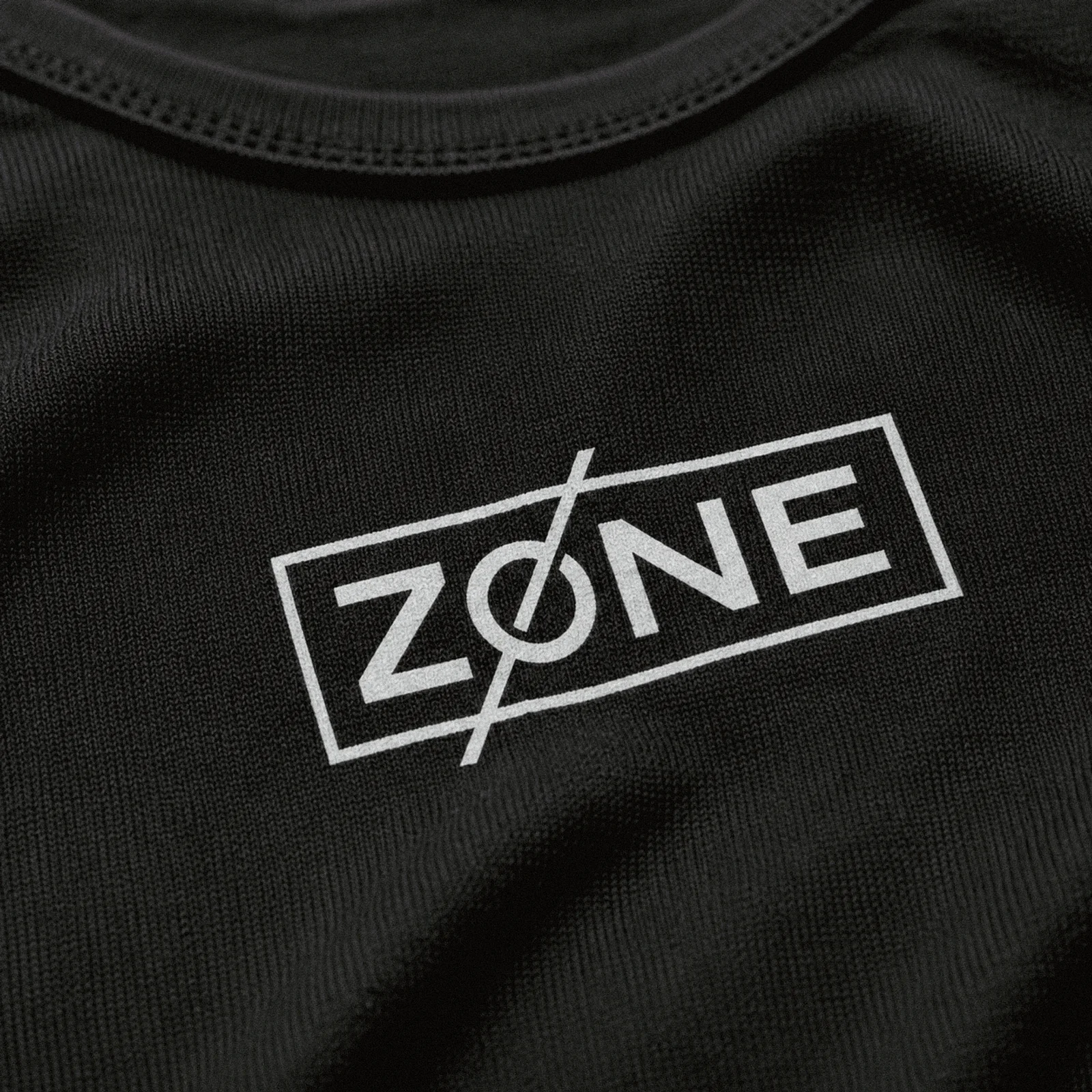 Macro close-up of the Zone mark printed on black knit fabric
